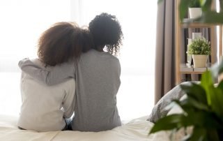 Two women hugging at home
